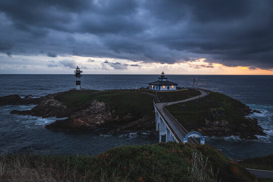 Dramatic stormy sky over Illa Pancha lighthouse at dusk