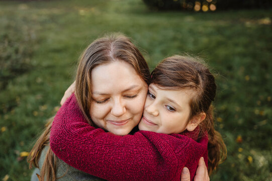 Mother Embracing Her Daughter During a Peaceful Autumn Moment