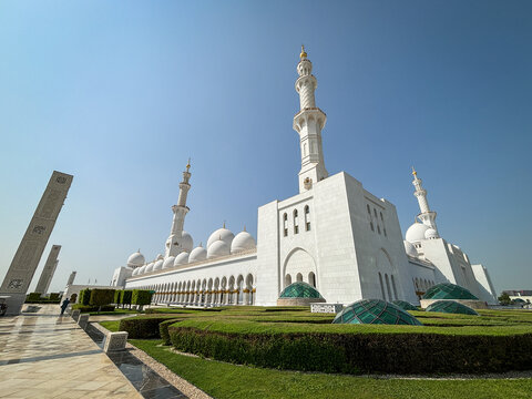 Clipped gardens leading the eye to the Grand Mosque in Abu Dhabi, United Arab Emirates