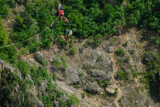 Two highliners crossing the same line above the Red Lake karst sinkhole near Imotski, Croatia