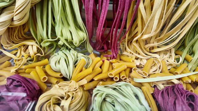Fresh handmade colored pasta, different shapes and sizes, on display in an italian shop window.