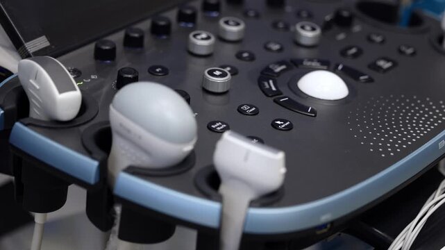 Ultrasound examination equipment with diagnostic probes and medical imaging console in close-up.