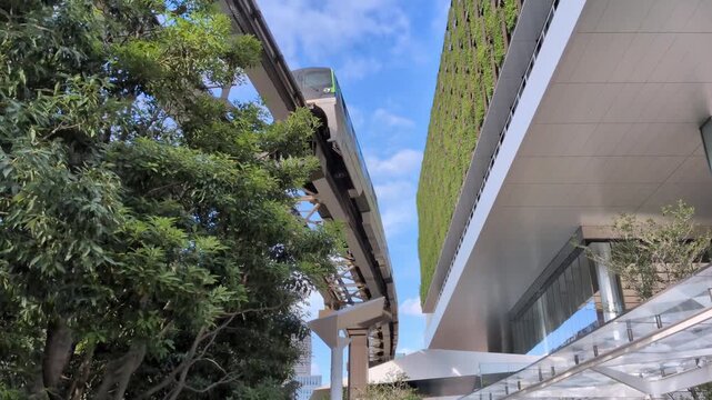 Sustainable modern building with vertical garden and monorail train in Tokyo Japan
