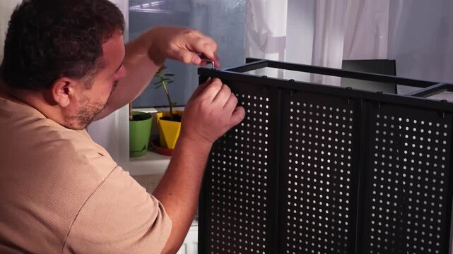 a man assembles a metal cabinet