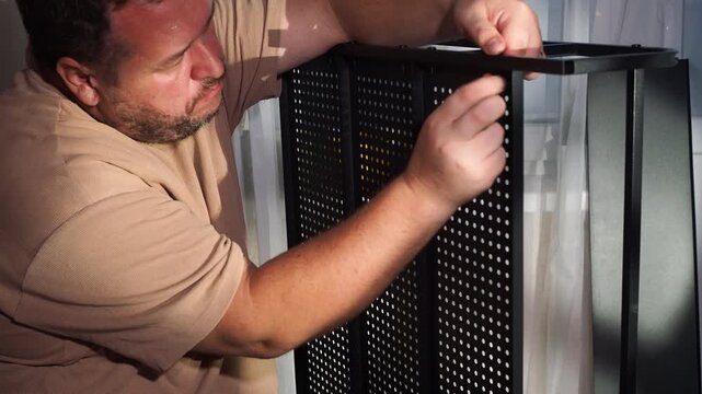 a man assembles a metal cabinet