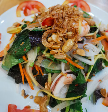 Fresh vietnamese salad with seafood, greens, carrots, and fried shallots