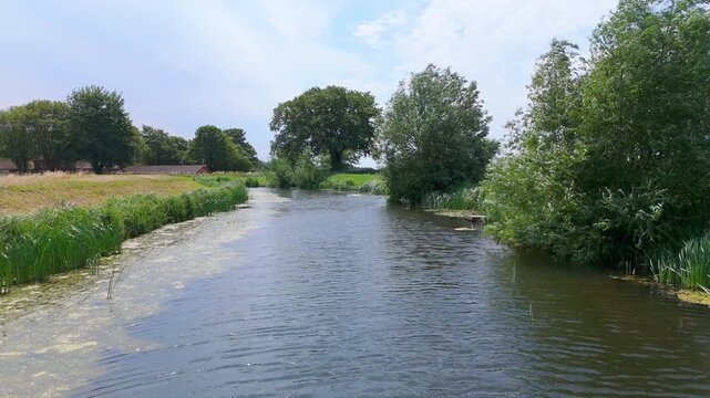 Peaceful river flows through green countryside
