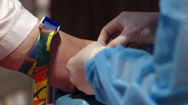 Preparation for venous blood collection from patient arm with tourniquet. Close up of medical procedure before blood test in clinic or hospital.