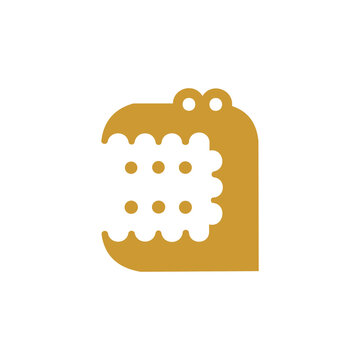 A gold-toned vector icon or graphic logo cleverly depicting a cute cartoon crocodile or alligator biting into a polka-dotted biscuit or cracker. The clean, flat silhouette design makes it ideal 