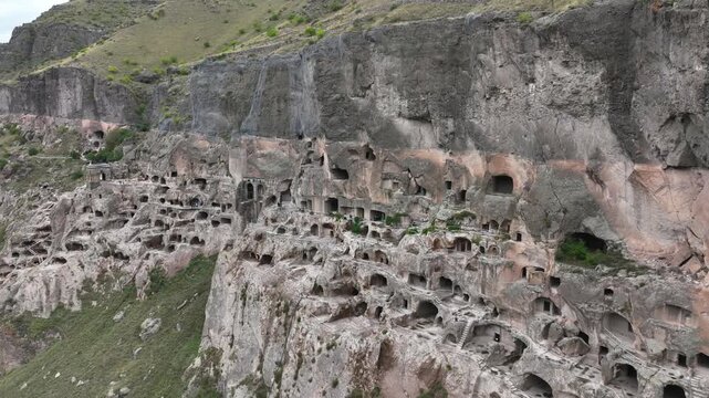 Aerial view of the ancient Vardzia cave monastery complex carved into the rock face of the Erusheti mountain, a historical landmark and tourist attraction in Georgia