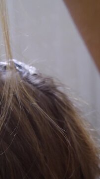 Women's Hair Salon. The stylists at the women's salon are working with a young woman. Beauty salon and makeup - vertical video.