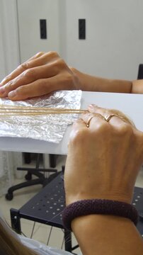 Women's Hair Salon. The stylists at the women's salon are working with a young woman. Beauty salon and makeup - vertical video.