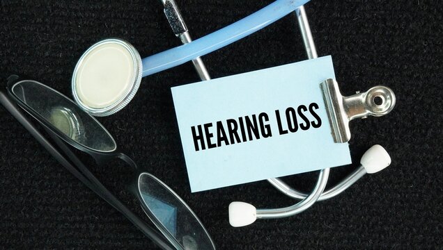 Stethoscope and paper with the words Hearing loss is a partial or total inability to hear sounds, ranging from mild to profound