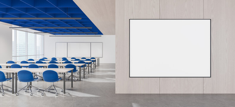 Modern classroom interior with blank framed poster wall mockup, blue ceiling, desks and chairs for educational presentation design concept. 3D Rendering
