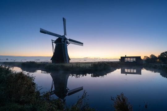 A traditional windmill during a tranquil, autumn dawn in the Dutch countryside. Krimstermolen, Zuidwolde.
