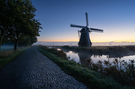 A traditional windmill during a tranquil, autumn dawn in the Dutch countryside. Krimstermolen, Zuidwolde.