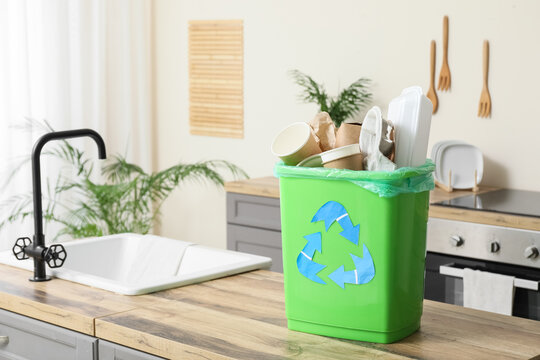 Recycling and waste management, green bin with paper and plastic trash in a home kitchen for sustainable living and environmental conservation efforts