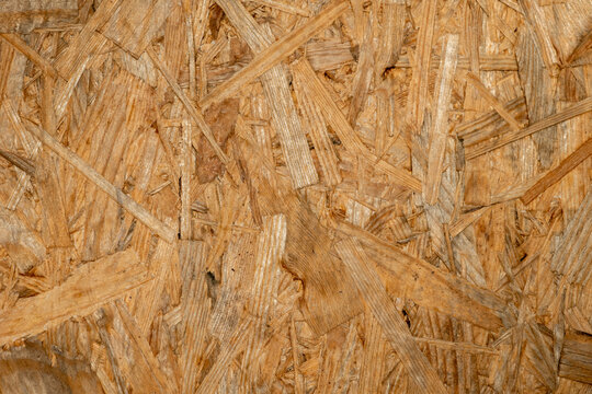 oriented strand board texture macro view background, OSB wooden board surface with pressed wood flakes close up, close up view of pressed chipboard texture background