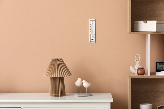 Climate control and home comfort, wall thermometer with room temperature measurement in a modern living room interior with minimalist decor