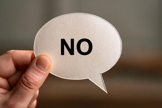 Hand holding paper speech bubble with word no for rejection concept
