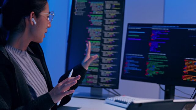 Programmer Woman Developer Coding Software Source Code Computer Monitor Screen Analysis in Dark Office, Explaining Syntax with Focused Concentration, Creative Energy, and Expressive Communication