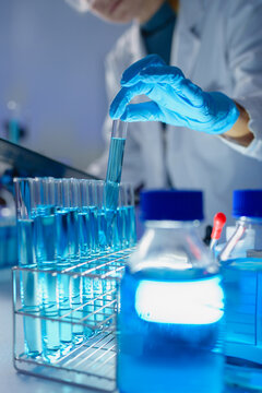 Scientist holding test tube with blue liquid in laboratory
