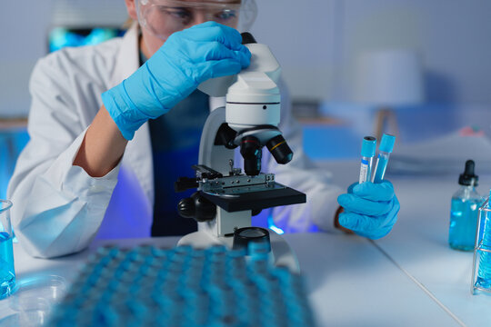 Scientist analyzing samples using microscope in laboratory