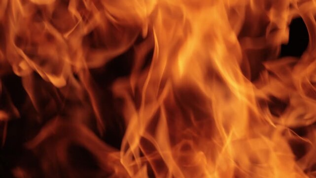 Abstract background of bright orange flames flickering intensely in dark night environment.