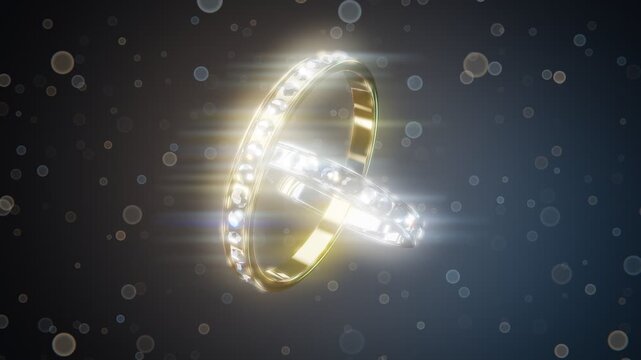 Interlocking wedding rings in gold and silver with sparkling diamonds and bokeh particles