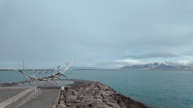 An iconic view of the Sun Voyager statue and Mt. Esja in Reykjavik, Iceland.