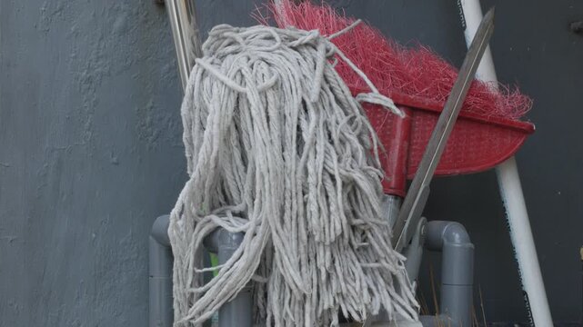 Hand Organizing and Arranging a Mop for Household Cleaning