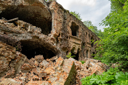 Old building shows signs of ruin with collapsed bricks and broken walls, overtaken by greenery and nature in the area