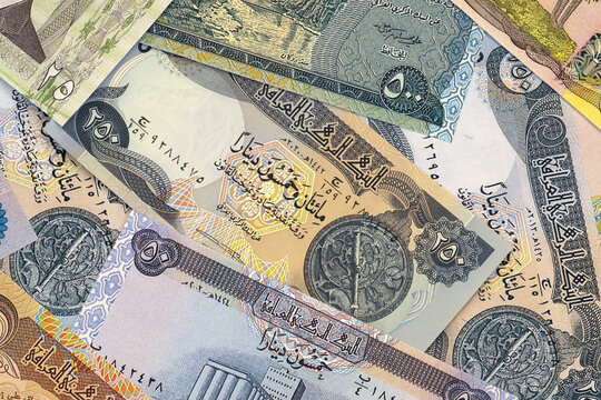 Iraqi dinar money bills in pile on table. Iraq IQD currency cash close up