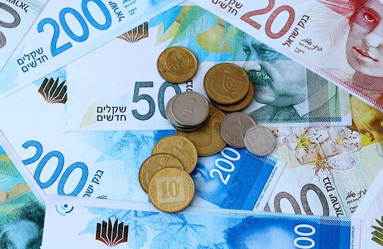 Israeli shekel money banknotes and coins on table. Israel cash bills of ILS currency