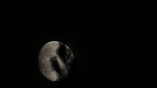 Waxing moon gliding across the night sky with trees..Continuous motion captured in time lapse