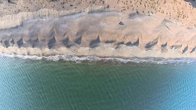 Travel and History: Top-Down Aerial Drone Shot of Waves Breaking on Shingle Beach at Southsea Seafront in Portsmouth, Hampshire