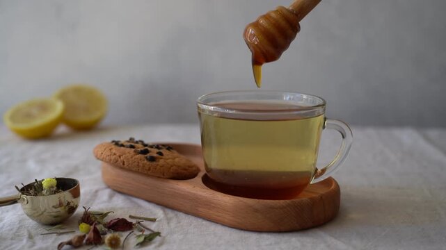 Adding natural honey to a cup of hot tea, close up of sweetener being poured into a warm homemade beverage