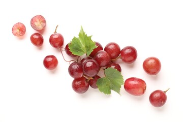 Fototapeta premium Fresh ripe grapes and green leaves on white background, flat lay