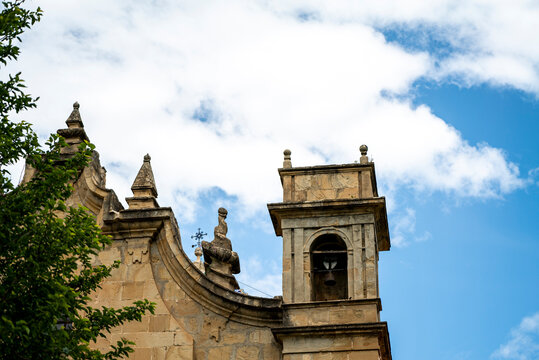 Baroque church bell tower against blue sky with clouds