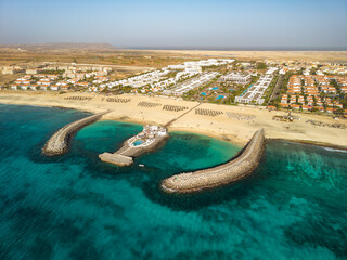 Fototapeta premium Aerial view of beachfront resort complex with breakwaters on Sal, Cape Verde