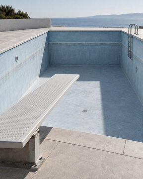 Diving Board Over Empty Swimming Pool as Water Scarcity Concept