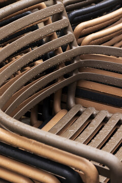 Rain-Soaked Stacked Chairs at an Outdoor Cafe in Late Autumn. Close-up.