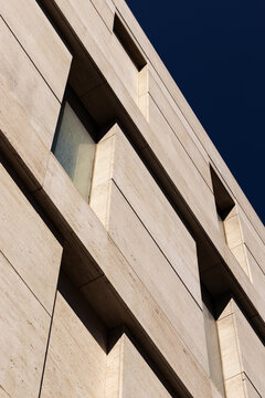 Rough Stone Building Facade Against the Sky with Deep Shadows.