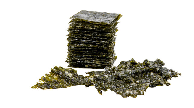 Isolated crispy roasted seaweed snack sheets and crumbled pieces for healthy Asian food