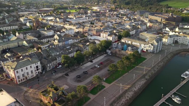 Aerial panoramic views of Whitehaven coastal town and civil parish. Town centre with architecture and main roads with moving vehicles in Sunrise, golden hour. Drone POV exploration of Devon County, UK