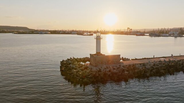 Sea lighthouse sunset aerial view Varna port breakwater golden hour light maritime navigation concept Varna Bulgaria travel tourism landmark horizontal video stock footage