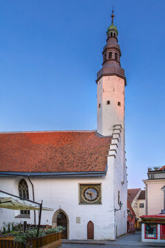 Church of the Holy Spirit side view with public clock in Tallinn, Estonia. Sunny day view of medieval architecture