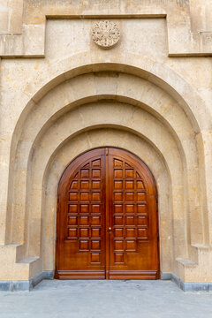 Layered carved stone arches with textured ornament frame the wooden entrance doors of Saint Gregory the Illuminator Cathedral in close up detail, Yerevan, Armenia