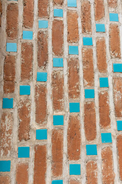Close up detail of a weathered brick wall decorated with small turquoise ceramic tiles arranged in a geometric pattern at the historic Blue Mosque complex, Yerevan, Armenia