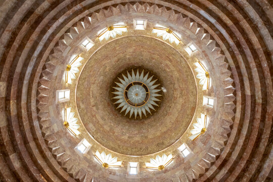 Circular domed ceiling of the Quba Mere Diwane Yezidi temple featuring a symmetrical star shaped light fixture surrounded by carved stone patterns and a skylight, Aknalich, Armenia